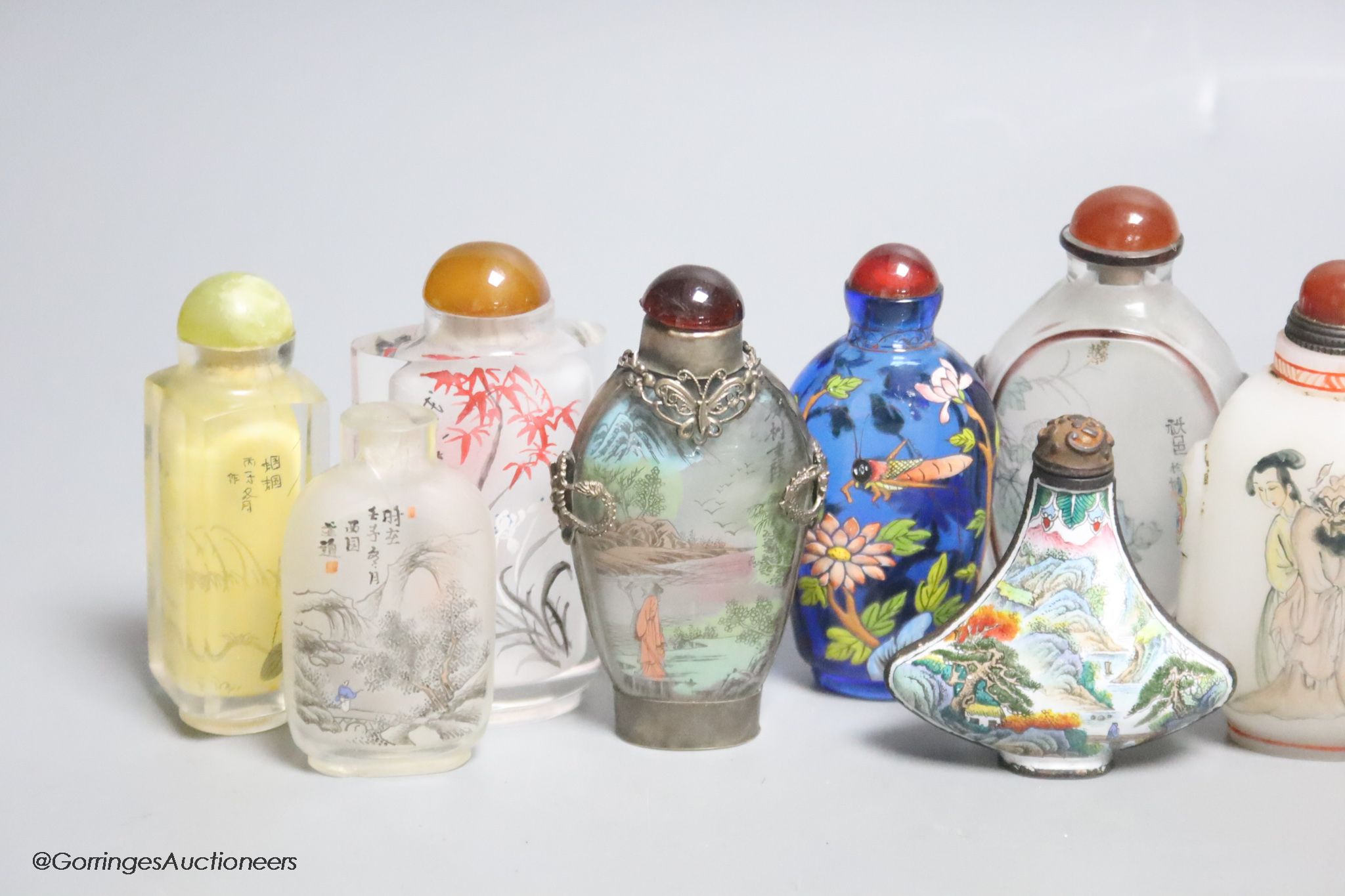 Eleven Chinese painted glass snuff bottles, a glass enamel one and another enamel one